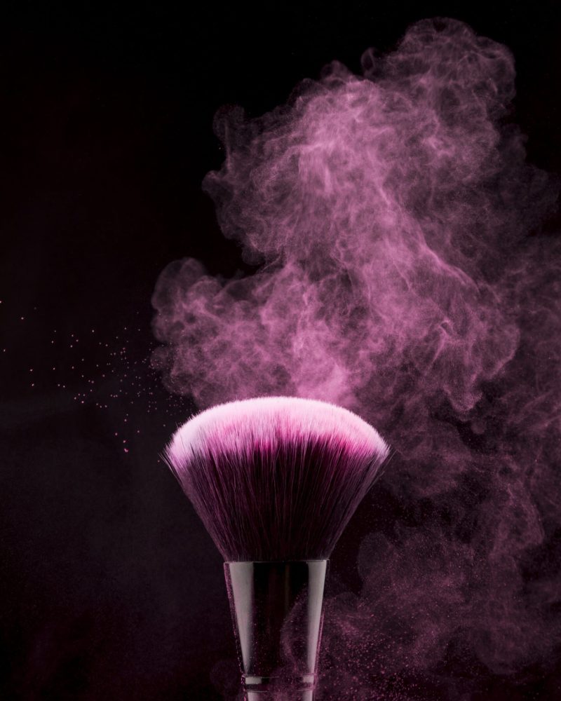 makeup-brush-with-flickering-pink-powder-splash-min